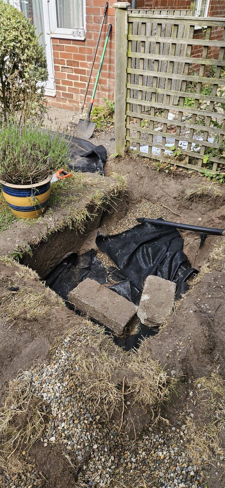 Drainage excavation opened in a rear garden for access on the plot