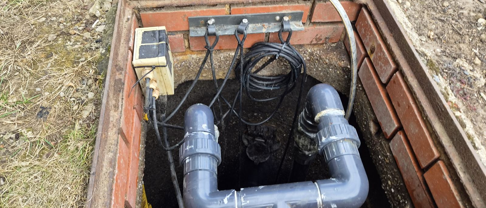 Open pump chamber showing twin pumps, pipework and lifting chains